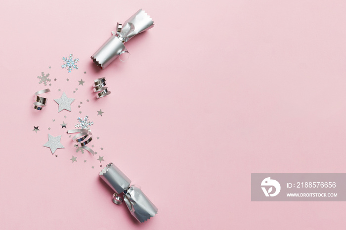 Christmas crackers with shiny confetti on color background, top view, copy space