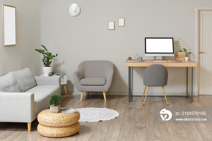 Interior of modern room with workplace, sofa and armchair