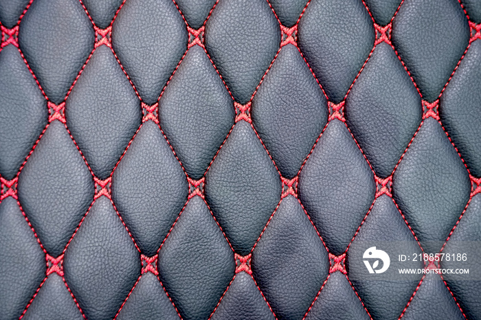 Close up red thread lines in rhombus pattern on surface of black genuine leather car seat background