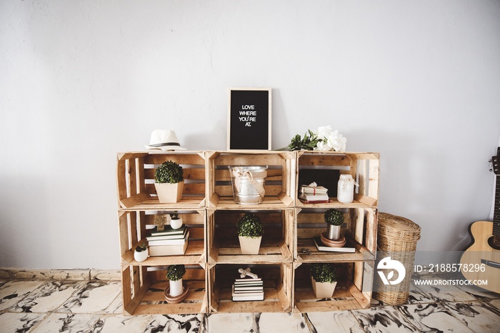 Closeup of a wooden shelf with plants and a sign on top of it