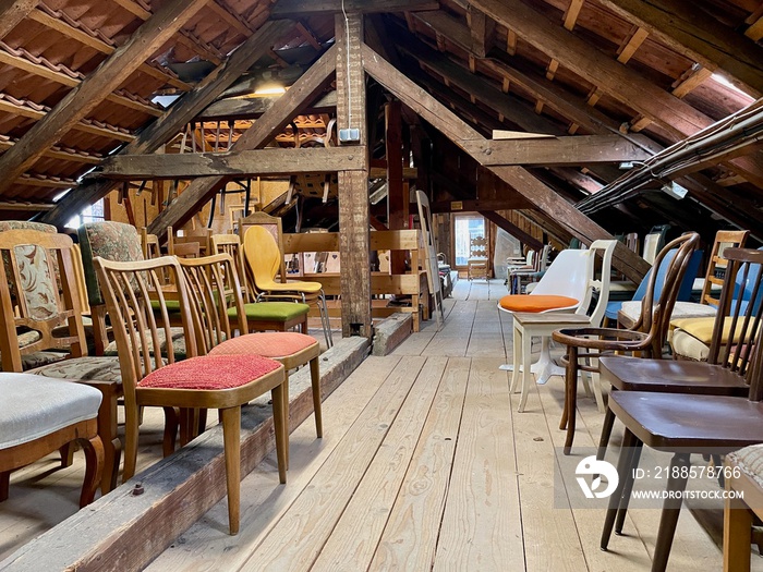 Old wooden attic with vintage chairs.