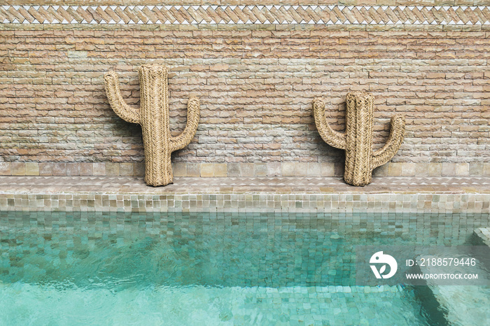 Decoration of swimming pool with wooden wicker straw cactus. Mexican style.