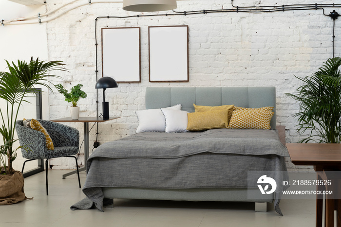 Industrial interior of bedroom with white  bricky wall in scandinavian style. Frames with mock up.