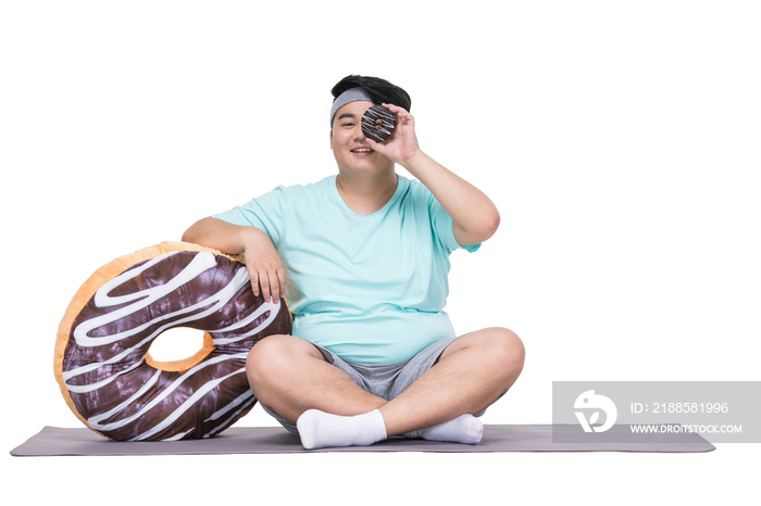 肥胖的青年男子拿着甜甜圈做运动