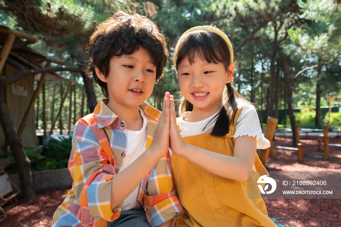 两个小孩子开心击掌庆祝