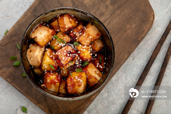 Traditional homemade fried tofu with sesame on light gray background.