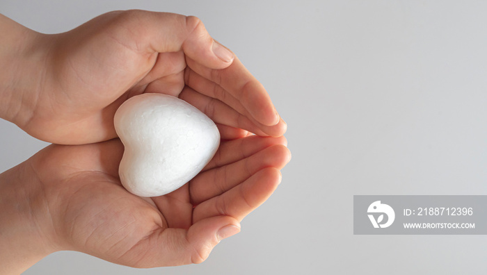 boy holding white heart in palm. Organ donation and insurance concept. World heart health concept. World organ donation day. Concept of healthy heart for healthy life. selective focus