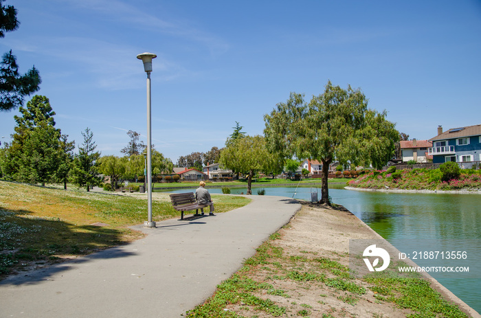 Lonely grandfather is sitting on a bench in the park, Newark, California