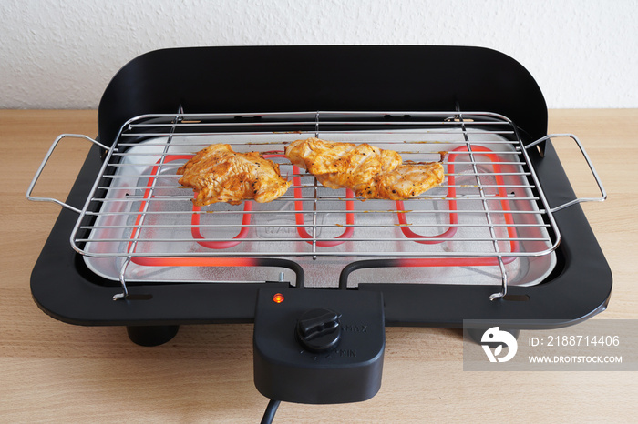 grilling marinated grilled chicken on electric table grill