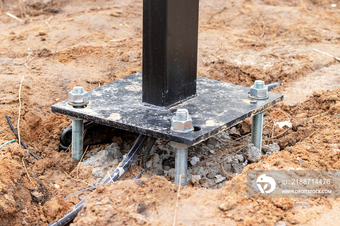 Pouring concrete, preparing anchors, wiring electrical cables, installing a lighting column or billboard. Post installation on damp ground of a construction site. Selective focus