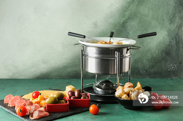 Cheese fondue with snacks on table