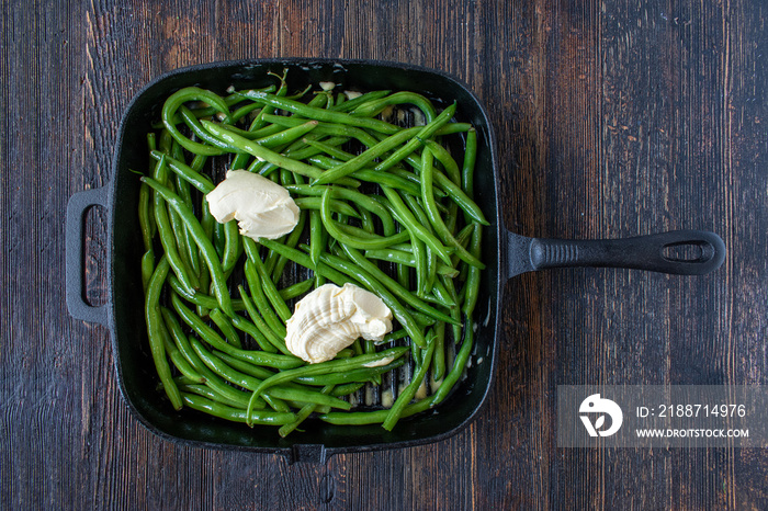 farm fresh whole green beans with butter in cast iron flat lay