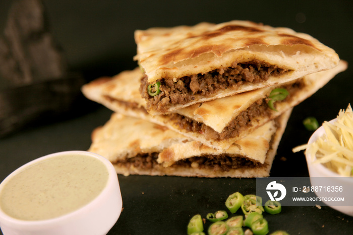 Smoked Minced Meat Stuffed Naan with Green Chillies on Black background