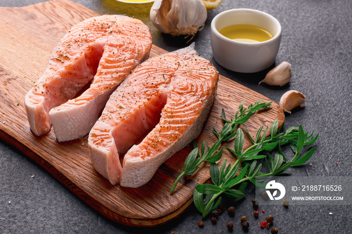 Raw salmon steaks on a cutting board close up