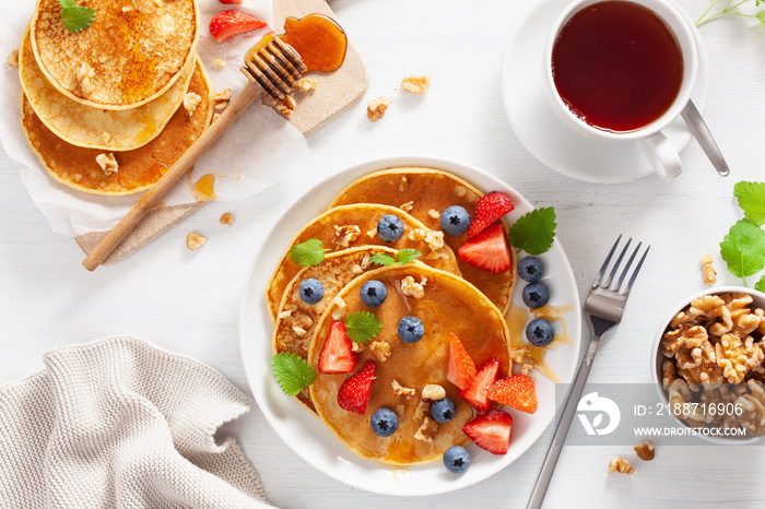 pancakes with blueberry strawberry honey and nuts for breakfast