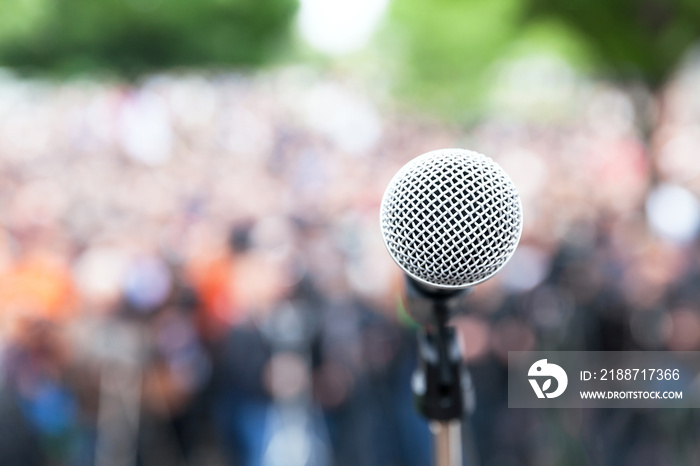 Microphone in focus against blurred protest or public demonstration