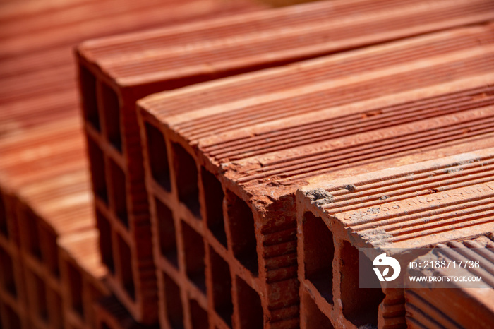 Detalhe de tijolos empilhados. Tijolos cerâmicos dispostos em pilhas e armazenados ao ar livre para venda.