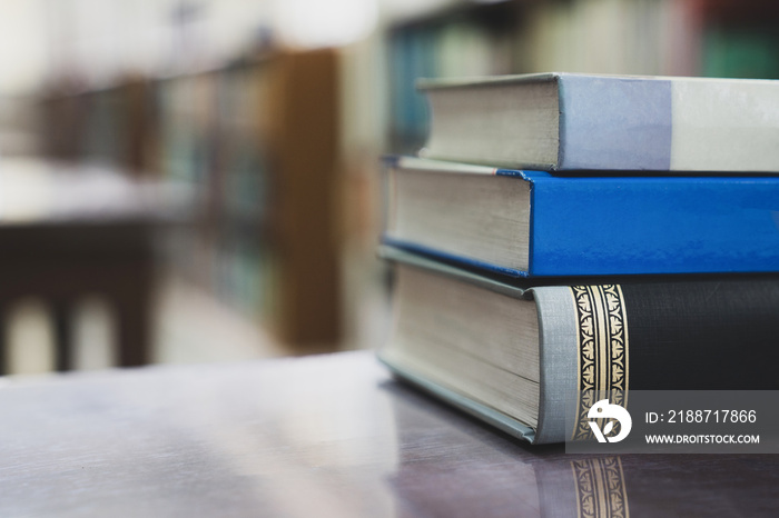 Education learning concept, Books on the desk in the auditorium, Book stack on wood desk and blurred bookshelf in the library room, Education background, Back to school concept