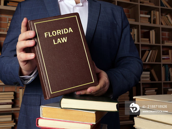 Lawyer holds FLORIDA LAW book. Florida residents are subject to Florida state and U.S. federal laws