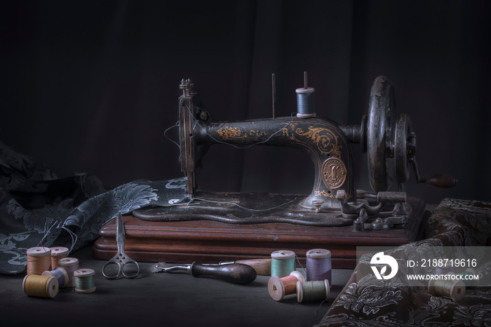 The sewing machine and accessories - threads, needle, scissors, measuring tape.