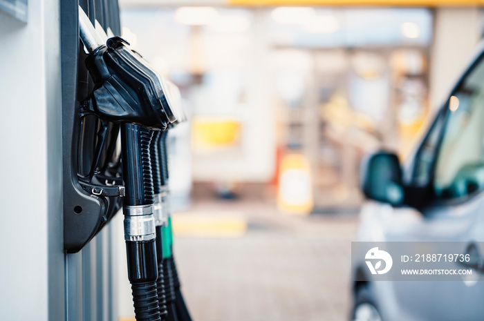 Closeup of woman pumping gasoline fuel in car at gas station. Petrol or gasoline being pumped into a motor. Transport concept