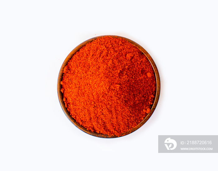 Top view of red chili powder in wooden bowl isolated on white background