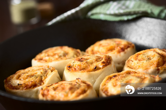 Frische hausgemachte Pizzaschnecken gefüllt mit Schinken, Zwiebel, Tomatensauce und Käse, fotografiert mit natürlichem Licht (Selektiver Fokus, Fokus in die Mitte der mittleren Schnecke)