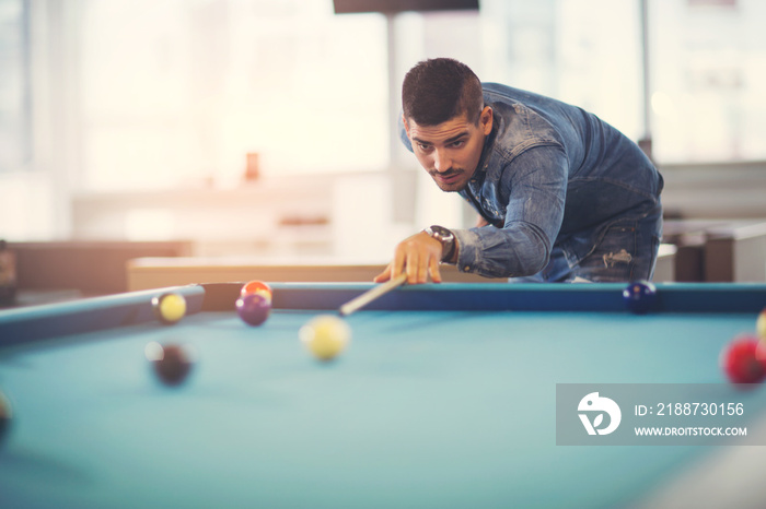 Handsome man playing pool in pub