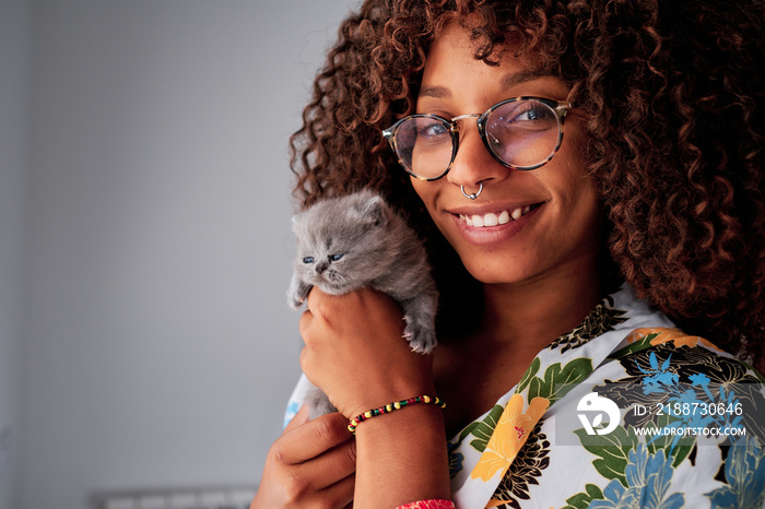 young black woman with curly hair with a little exotic grey cat