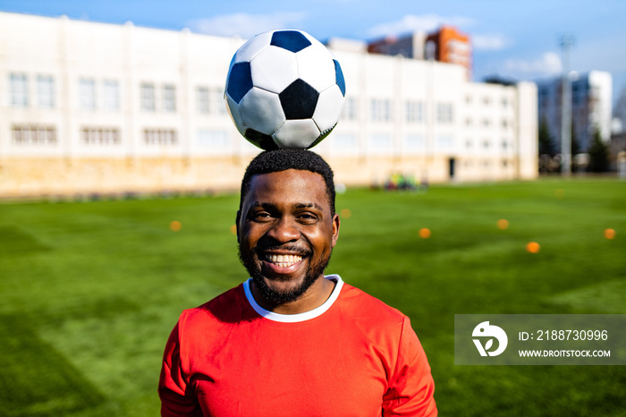 happy multicultural hispanic soccer player smiling and wear red sporty suit outdoor sunny day