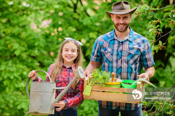 Planting season. Family garden. Maintain garden. Planting flowers. Family dad and daughter planting plants. Transplanting vegetables from nursery or gardening center. Plant your favorite veggies