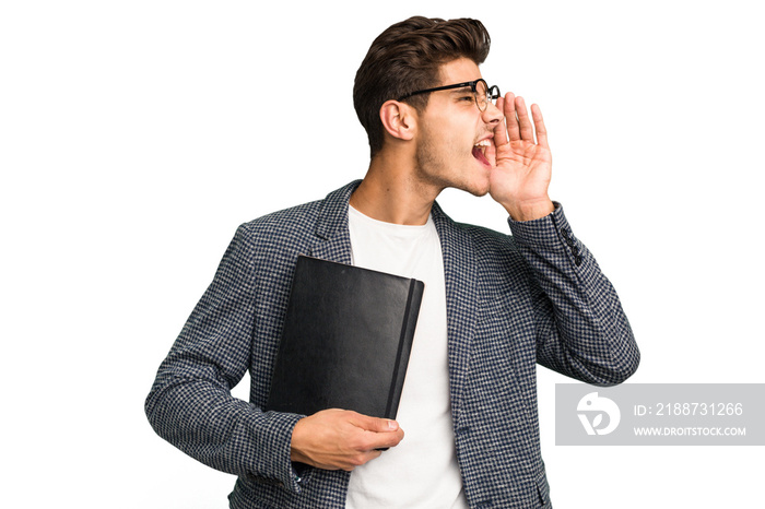 Young teacher caucasian man holding a book isolated shouting and holding palm near opened mouth.