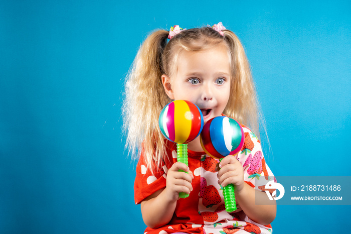 A thoughtful girl in red dances with maracas. The concept of children’s creativity, the development of musical abilities, gifted children, preschool education, fun pastime.