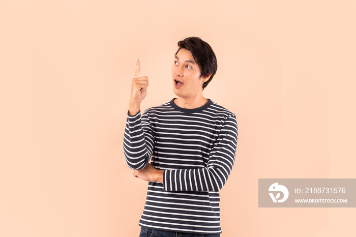 Young handsome Asian man / happy guy pointing to above copy space to think and get idea inspiration isolated over blank .background, studio shot