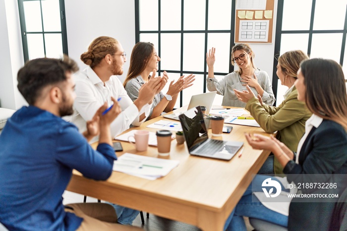 Group of business workers smiling and clapping to partner at the office.