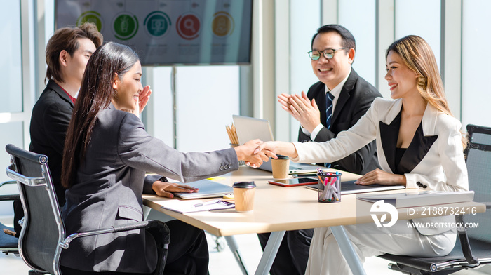 Millennial Asian successful professional male businessmen and female businesswomen audiences in formal suit sitting together shaking hands in company conference office meeting room.