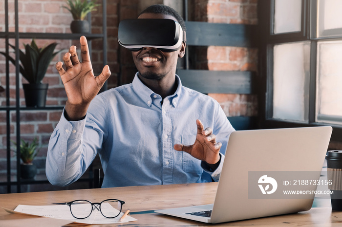 African businessman exploring opportunities of virtual reality in loft office, using VR headset