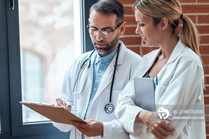 Confident female and male doctors talking about medical information in medical consultation.