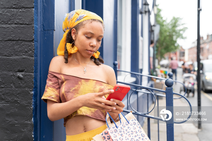 Young woman using smart phone in city