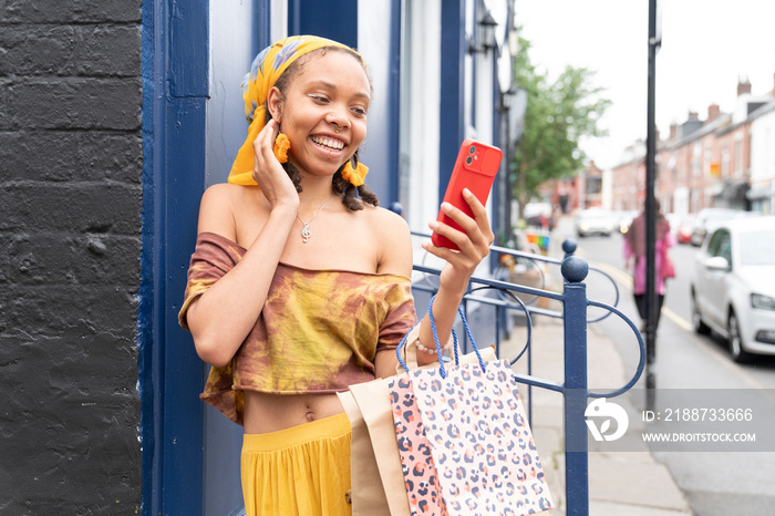 Smiling woman taking selfie with smart phone in city