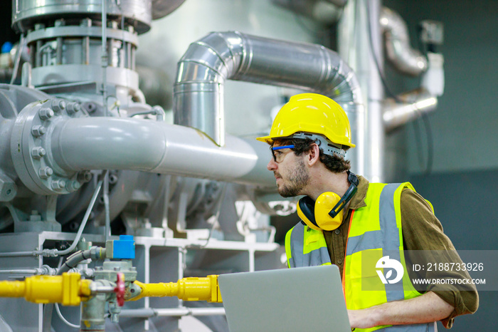 Engineer manual workers standing in a aluminum mill and working together. used professional equipment. Manual workers cooperating while measuring a electronic