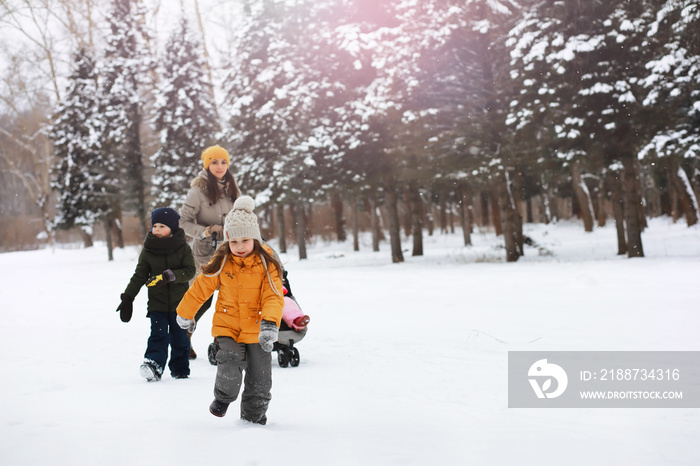 Happy family playing and laughing in winter outdoors in the snow. City park winter day.