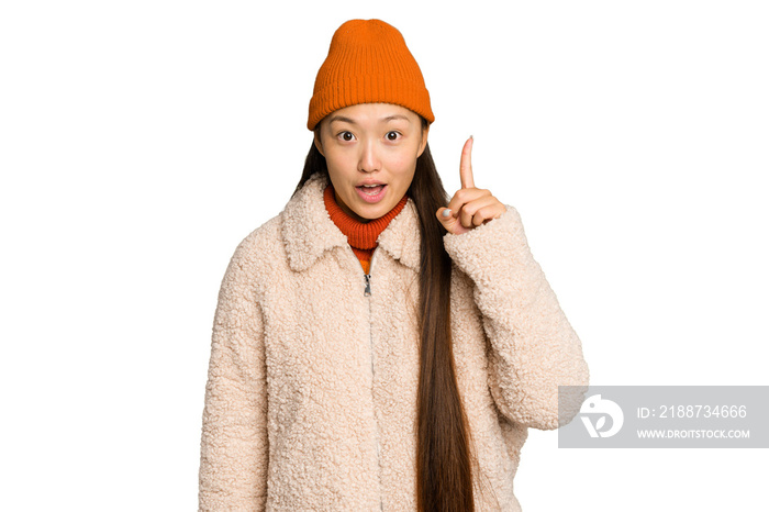 Young asian woman wearing winter clothes isolated on green chroma background having an idea, inspiration concept.