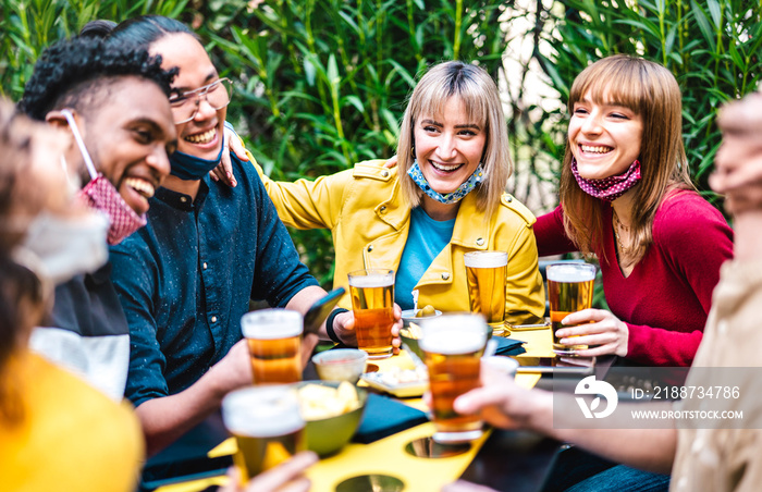 Multiracial people drinking beer with opened face mask - New normal friendship concept with friends having fun together on happy hour at brewery garden party - Vivid filter with focus on yellow jacket