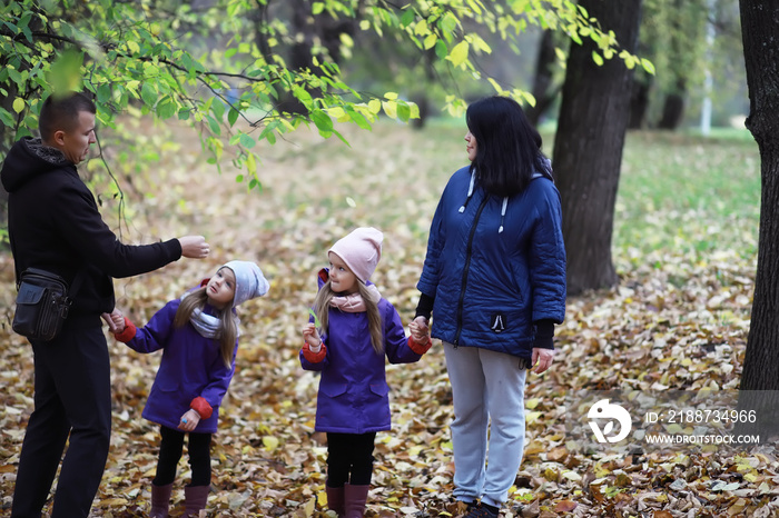 Leaf fall in the park. Children for a walk in the autumn park. Family. Fall. Happiness.