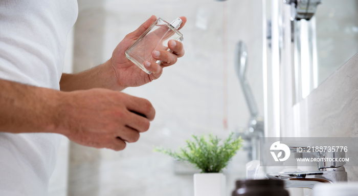 Glass bottle of perfume in the left hand of man