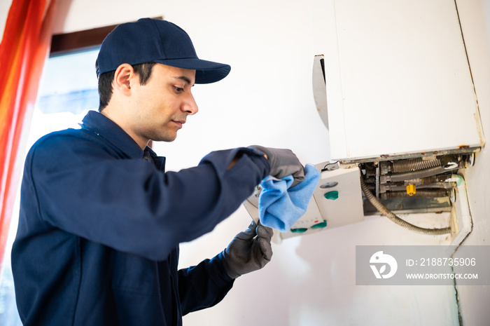 Smiling technician repairing an hot-water heater