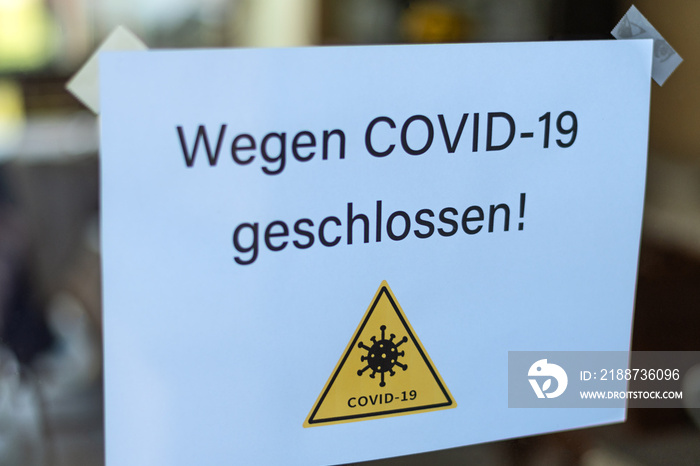 Biology and science. We’re closed or postponed sticker.  Virus or bacteria cells. Global alert. Epidemic. Text in German: Closed due to COVID-19.