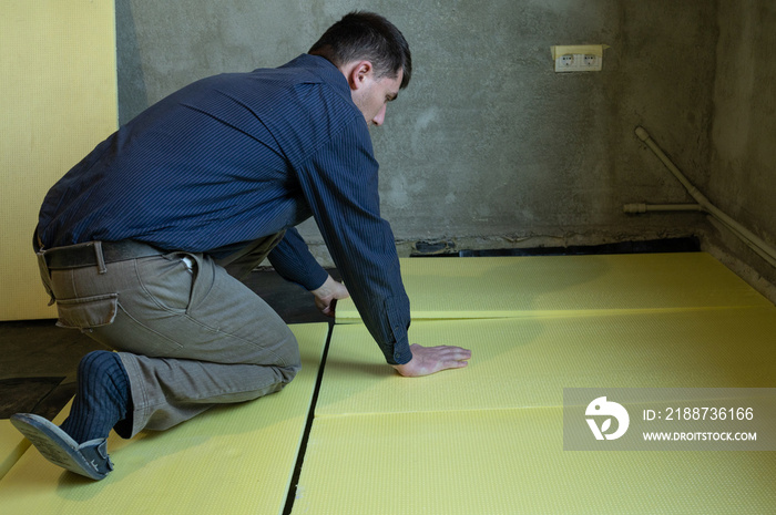 Installation of expanded polystyrene for floor insulation.