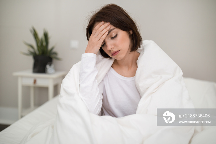 Sick young woman waking up with headache in the morning